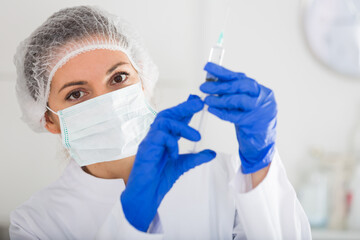 Young female nurse ready to make injection in hospital