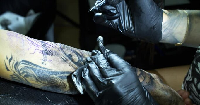 Tattooist draws a pattern on clients arm