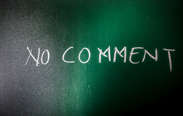 No Comment wrote on green board with chalk, a horizontal shot of No comment written on the blackboard.