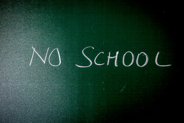 Shot of black board with written NO SCHOOL on it.