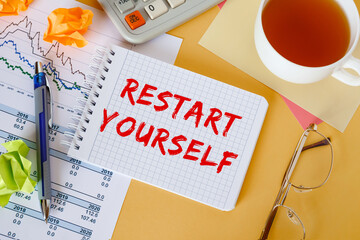 Desktop with documents, calculator and notepad. The inscription RESTART YOURSELF