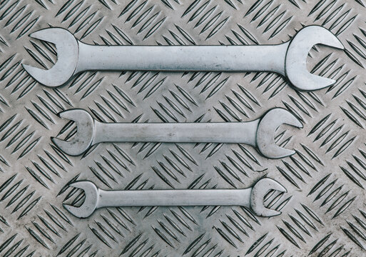 three spanners in a row on a metal background