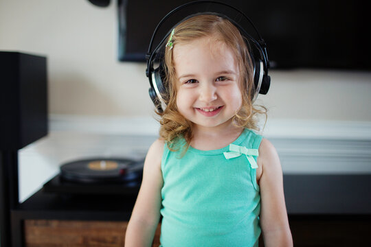Cute toddler listening to music with big headphones