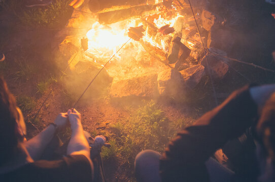 Grilling sausages on campfire