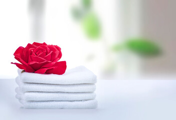 Obraz na płótnie Canvas Stack of white towels decorated with rose flower empty copy space.Household.