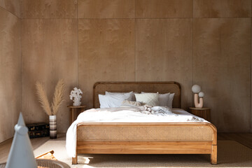 Stylish Bedroom corner with rattan headboard and bed with soft pillows setting with white pillows...