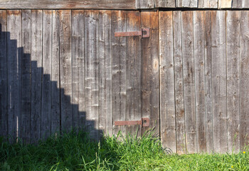 Old rustic wooden gate with rusty hinges.