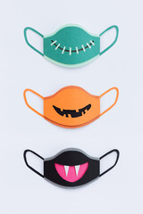 Paper facemask with halloween symbols on a white background. Paper art. Concept of a fun and safe celebration. Anti virus protection mask