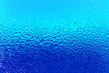 Fototapeta na wymiar Texture of Water Droplets on Chilled Drink Glass in Blue Color Gradation