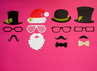 Santa Claus Mask And Three Cartoon Mask With Hat, Glasses And Bows With Christmas Decoration. Pink Paper Background With Copy Space