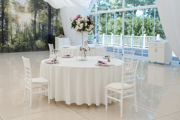 Wedding reception table in white style in the restaurant.