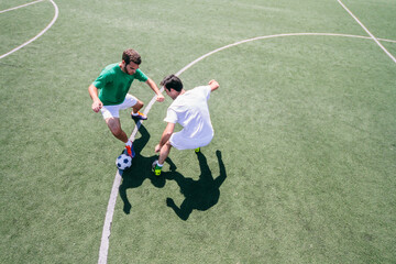 Two soccer players playing soccer in a soccer field during a soccer match