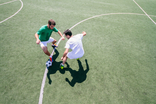 Two soccer players playing soccer in a soccer field during a soccer match