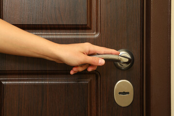 Young woman hand hold wooden door handle