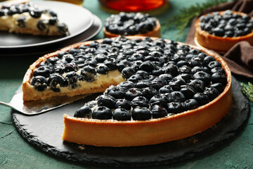 Concept of tasty lunch with blueberry pie on green background