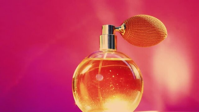 Golden fragrance bottle and shining light flares on pink background, glamorous perfume scent as holiday perfumery product for cosmetic and beauty brand, stock footage