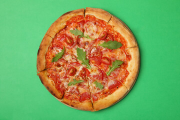 Tasty pizza with tomato on green background
