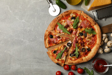 Tasty pizza and ingredients on gray background