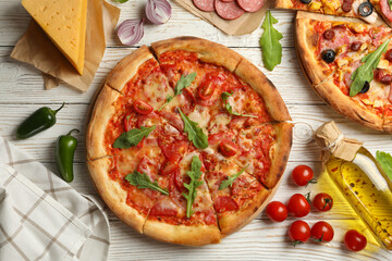 Tasty pizza and ingredients on wooden background