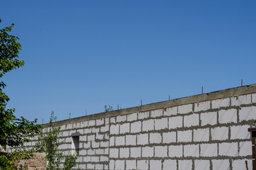 Stone wall with concrete and fittings against the blue sky.