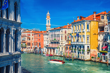 Fototapeta na wymiar Grand Canal waterway in Venice historical city centre with yacht boat, Venetian architecture colorful buildings and Church of the Holy Apostles of Christ bell tower. Veneto Region, Northern Italy.