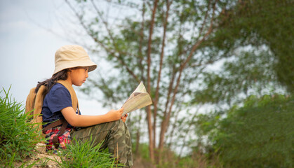 Kid girl Asian young woman holding camera and standing in the jungle adventure. Tourism for destination and leisure trips for education and relax in nature park.