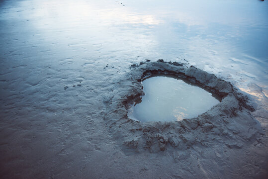 Heart shape hollow with water on wetland