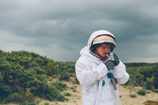 Man in spacesuit lighting up a cigarette.