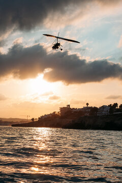 Deltaplan flying over the sea at Sunset