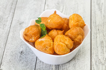 Sweet tasty profiteroles heap in the bowl