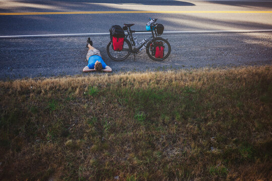 Young, fit man resting from bicycle touring expedition at sunrise