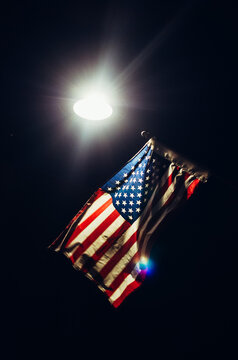 American flag lit by a streetlight at night