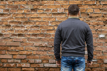 Man on the background of a red brick wall.