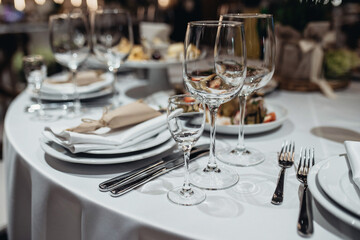 three glasses on the table to the right of the plate, table setting, two forks two knives
