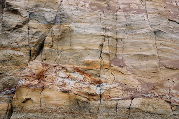 Soil layers of different colors in the canyon. Collapsed sand and clay slope.
