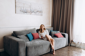 Obraz premium Calm millennial woman relaxing on soft comfortable sofa meditating or having daytime nap, carefree lazy girl breathing fresh air enjoying no stress free peaceful weekend morning resting on couch