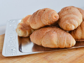 Heap of croissants on a metal tray close-up.