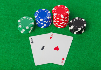Casino chips and playing cards on green table