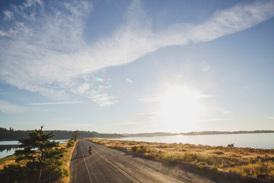 Young, fit man on bicycle touring expedition at sunrise