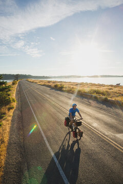 Young, fit man on bicycle touring expedition at sunrise