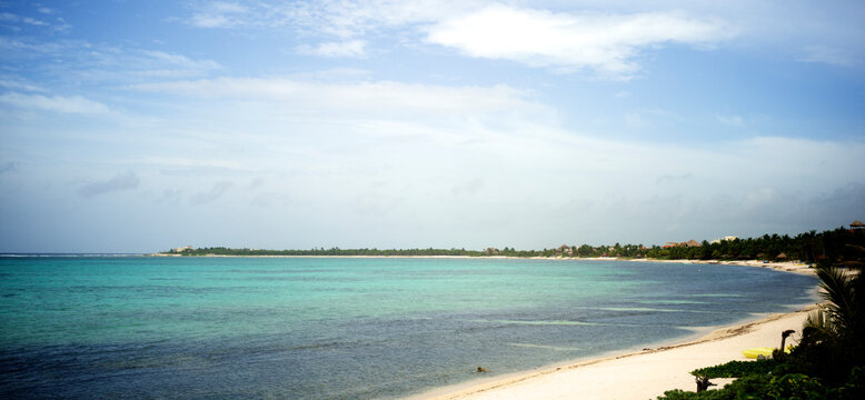 A Mexican beach with a clear lagoon and part of the Great Mayan reef in front