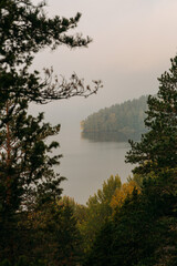 Scenic lake view with sunrise, island and foggy mood at beautiful autumn morning in Finland