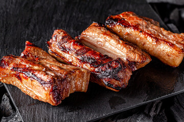 American cuisine. Fried pork ribs in josper. Serving food in a restaurant on a wooden board.