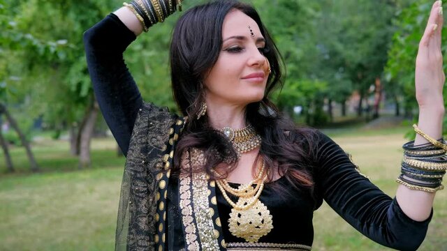 Portrait of a female model in ethnic indian costume with  jewellery and traditional makeup.  Woman in indian clothes dancing belly dance. Young beautiful woman in national costume dancing tribal dance