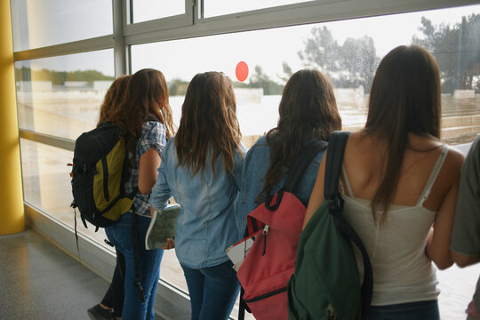 Group of student girls looking outside the window