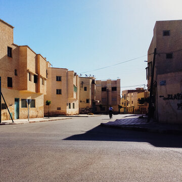 Man Riding Bicycle Through Moroccan Suburb