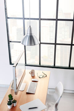 Cool workspace with computer on a wooden desk. Views of New York.