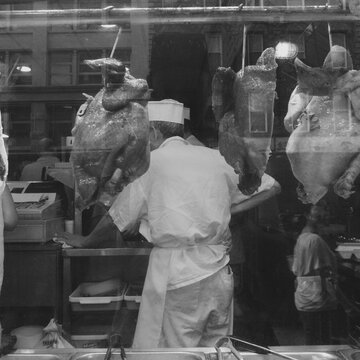 Black and white photograph of a chef in Chinatown making Peking Duck