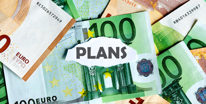 Focus on the word PLANS on the piece of torn white paper with EUROS currency as a background. Concepts of business.