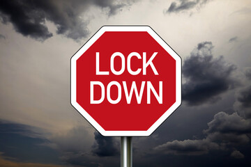 Roadsign STOP with Lockdown due to Covid-19 with dark sky in the background